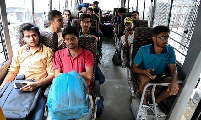 Tourists sit inside a bus as they leave Kashmir