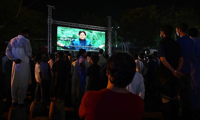 People watch Pakistan's Prime Minister Imran Khan addressing the United Nations General