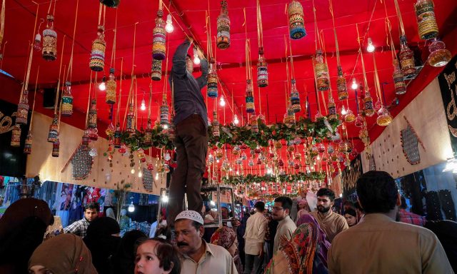 A man decorates a street to mark the birthday celebration of the Prophet Mohammed, in Lahore on November 9, 2019. - The birthday of Prophet Mohammed, also known as 'Milad', is celebrated during the Islamic month of Rabi al-Awwal, which falls on 12 Rabi al-Awwal in Islamic calendar.