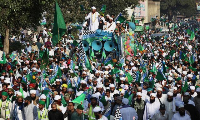 Men-wave-flags-as-they-attend-a-procession-to-mark-Eid-e-Milad-ul-Nabi-in-Lahore-on-Sunda.