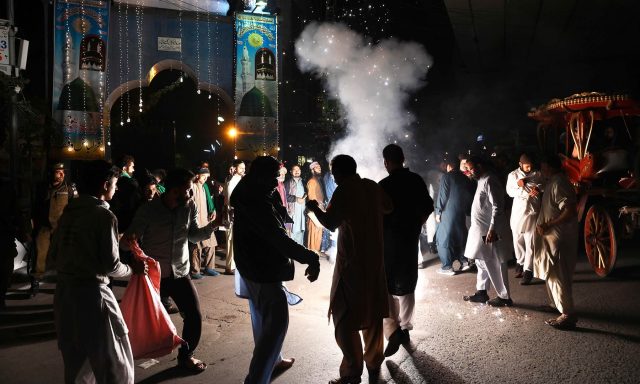 Pakistani men celebrate with fireworks the birthday of the Prophet Mohammed in Lahore on November 9, 2019. - The birthday of Prophet Mohammed, also known as 'Milad', is celebrated