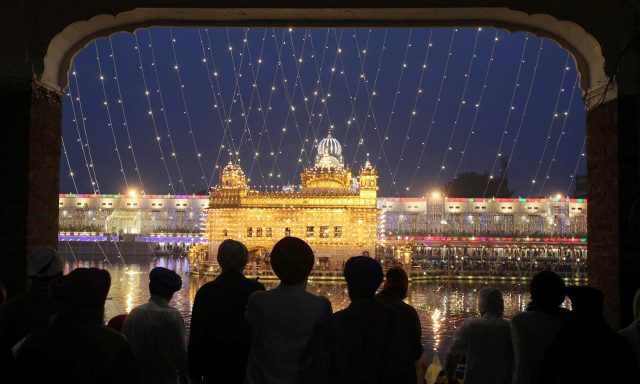 The-Golden-Temple-is-seen-illuminated-as-Sikh-devotees-arrive-on-the-eve-of-the-550th-birth-anniversary-of-Guru-Nanak