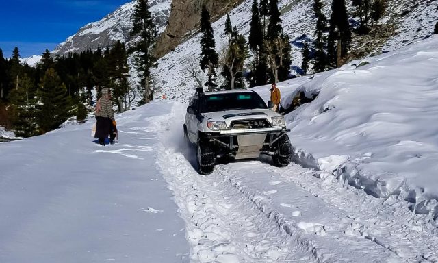 A Jeep races on a snow covered track in Mahodand Kalam